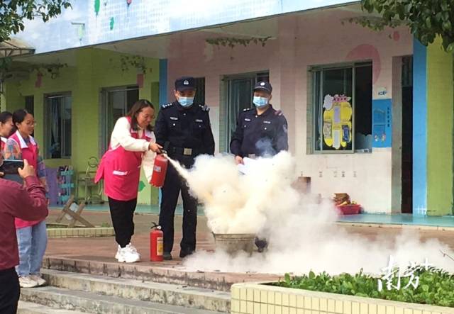 公安民警變身“消防安全老師”，指導(dǎo)幼兒園老師使用滅火器。